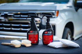 Warehouse interior with tall shelves stacked with products; signs above indicate sections.