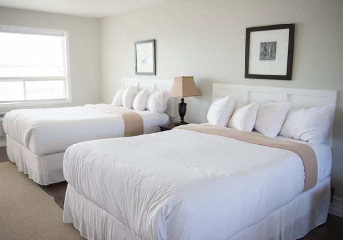 A hotel room with two beds and a lamp