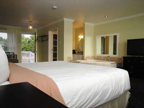 A hotel room with a king size bed and a jacuzzi tub.