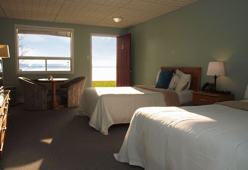 A hotel room with two beds and a table