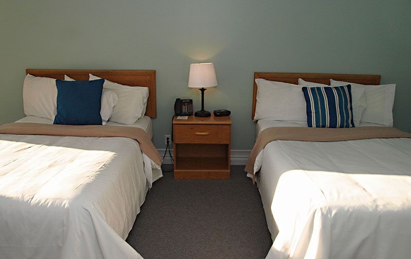 A hotel room with two beds and a nightstand