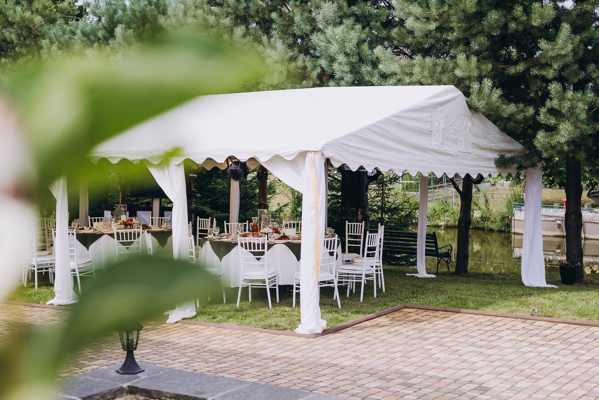A white tent with tables and chairs underneath it.