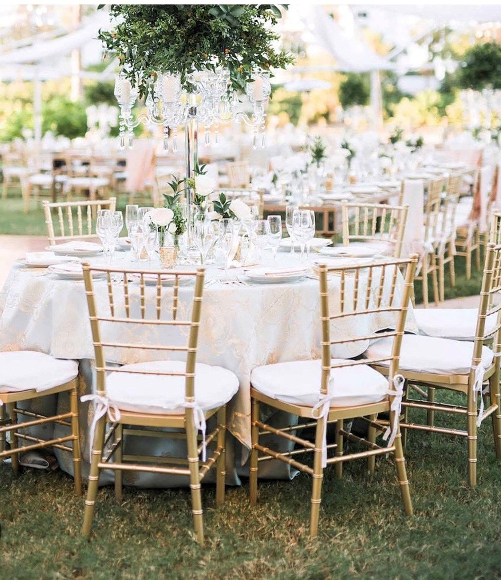 There are many tables and chairs set up for a wedding reception.