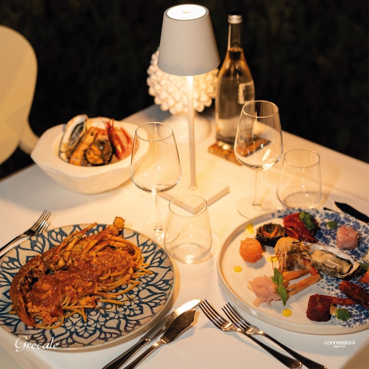 Un tavolo con piatti di cibo e bicchieri di vino