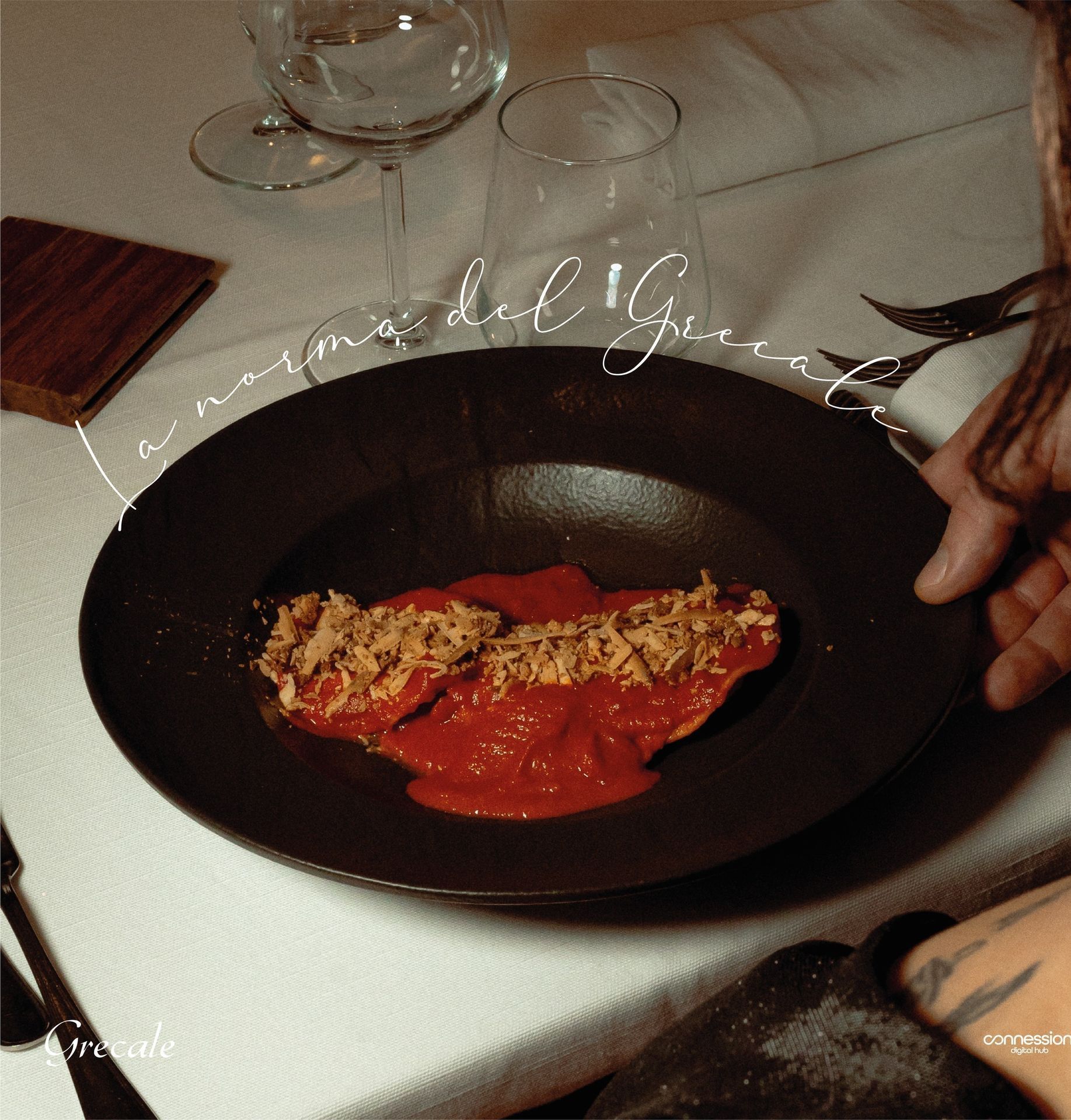 Una persona che tiene in mano un piatto nero con una salsa sopra