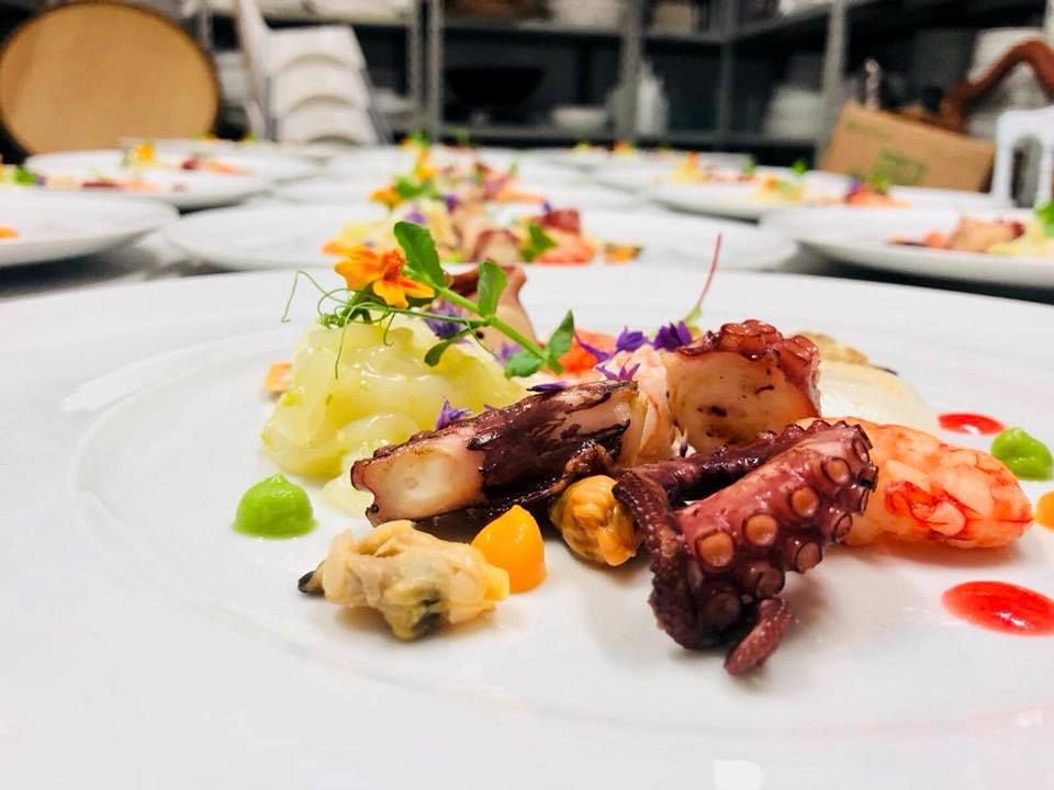 Un piatto di cibo con sopra un polpo e dei gamberi