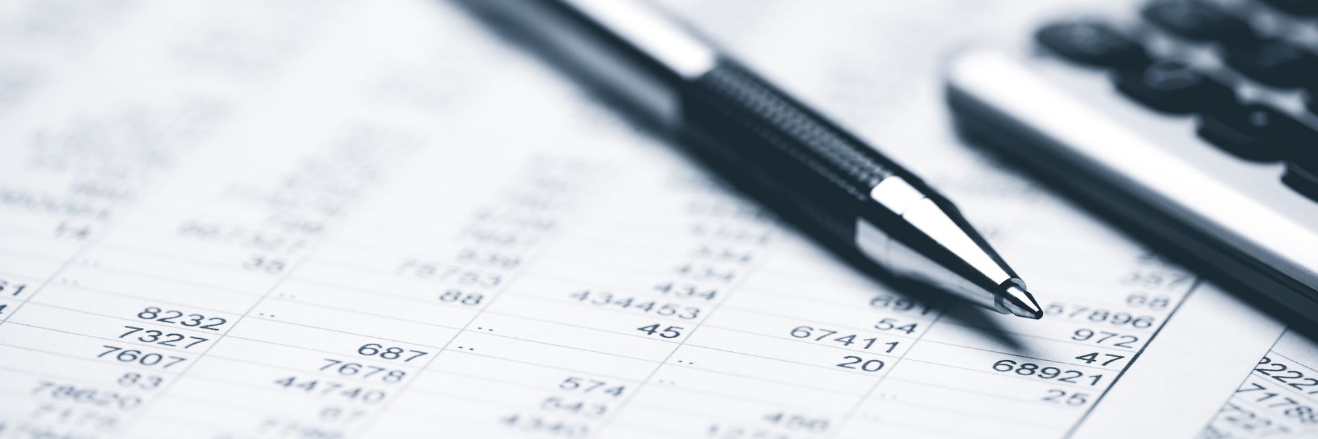 Pen on a ledger with a calculator in the background. Financial accounting.