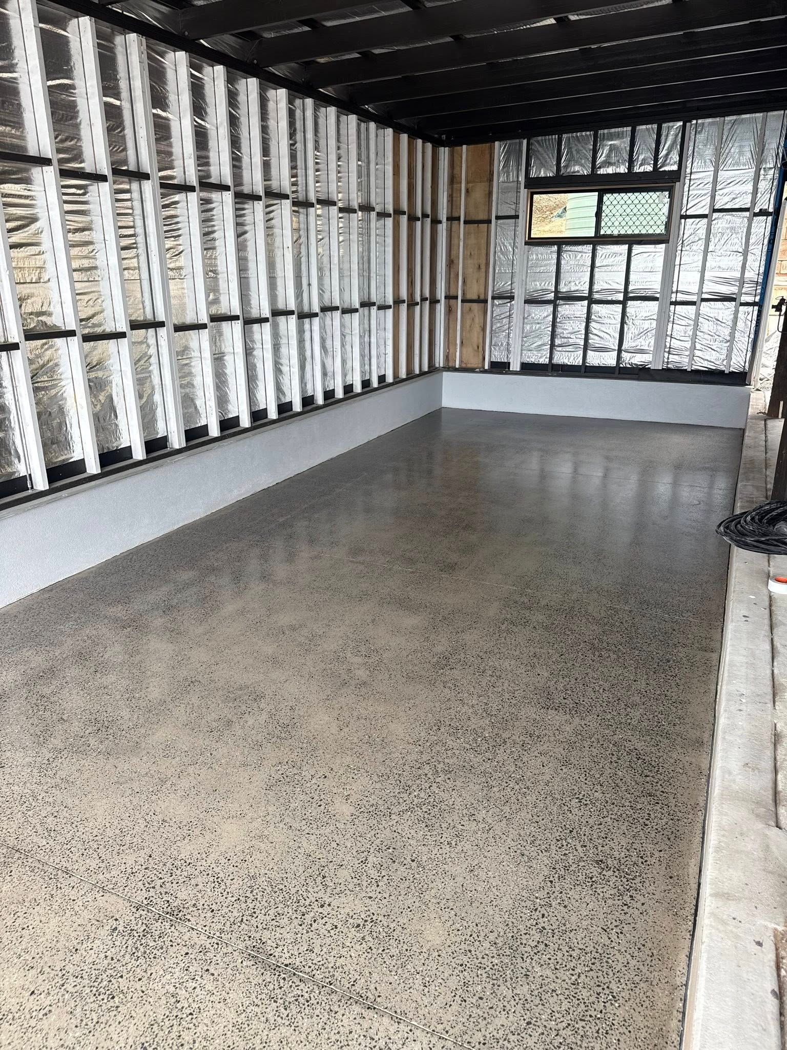 A Concrete Grinder on the Concrete Floor Of A Open Garage — All Grind & Coat in Cairns, QLD