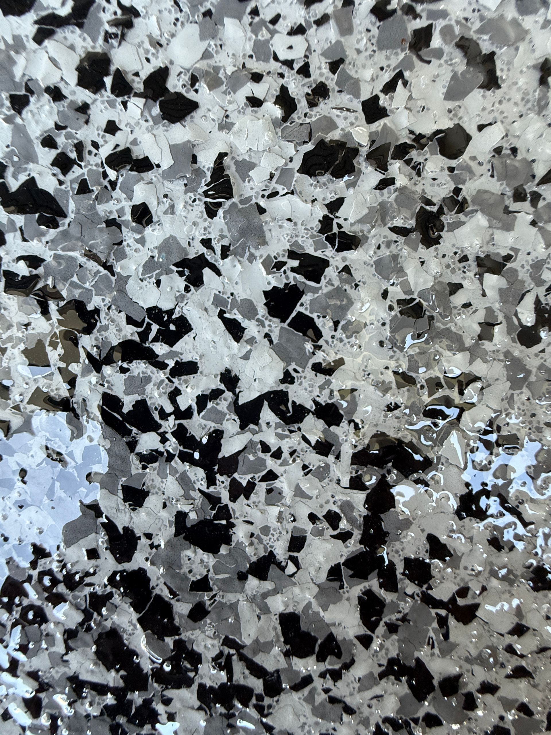 Close-up View Of A Speckled Floor With Black, Gray, And White Chips — All Grind & Coat in Cairns, QLD