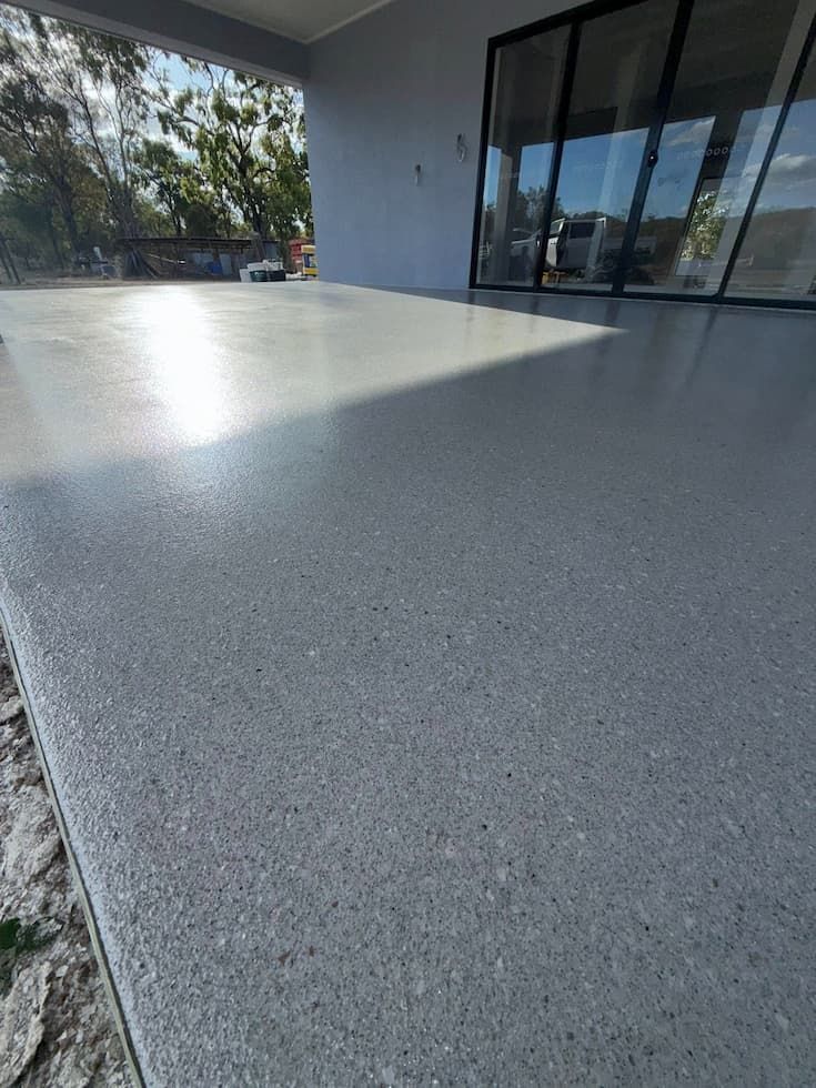 Smooth, Polished Concrete Patio Reflecting Sunlight Outside a Modern House