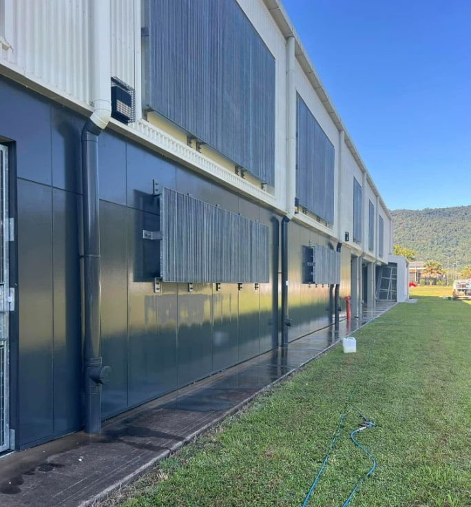 A Large Building With A Lot Of Windows And A Lawn In Front Of It — All Grind & Coat in Cairns, QLD