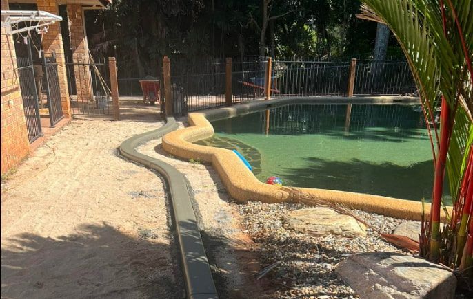 A Swimming Pool Is Being Built In The Backyard Of A House — All Grind & Coat in Cairns, QLD
