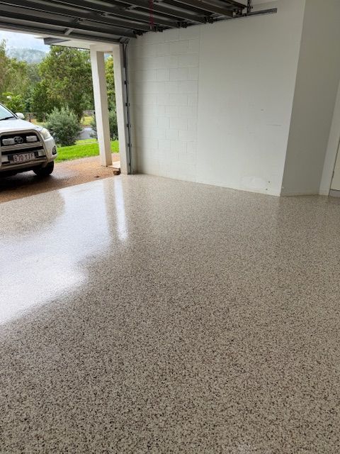 A Car Is Parked In A Garage With A Shiny Floor — All Grind & Coat in Cairns, QLD