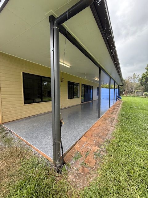A Large Covered Porch With A Drainpipe On The Side Of A House — All Grind & Coat in Cairns, QLD