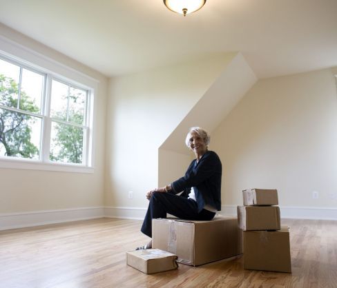 Woman sitting on boxes that were delivered by movers in Albany