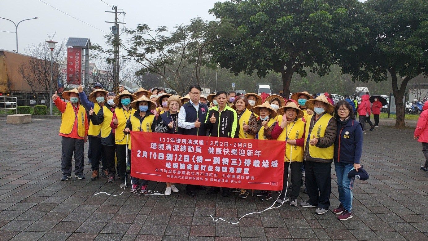 A group of people are standing in front of a red banner.