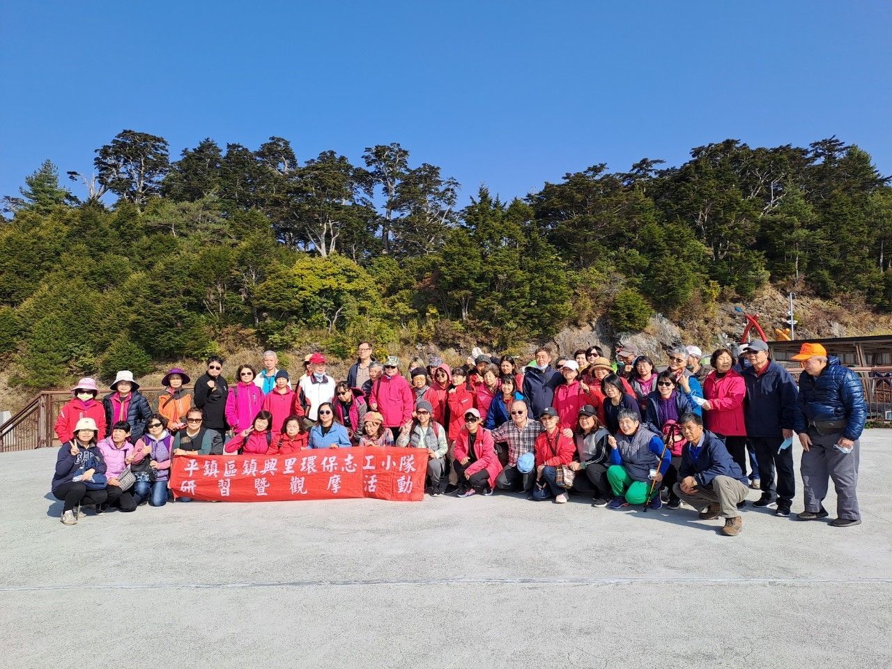 A man and a woman are holding a red sign in a room.