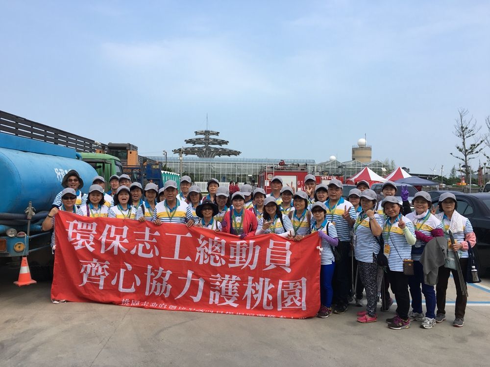 A group of people are posing for a picture in front of a large red banner.