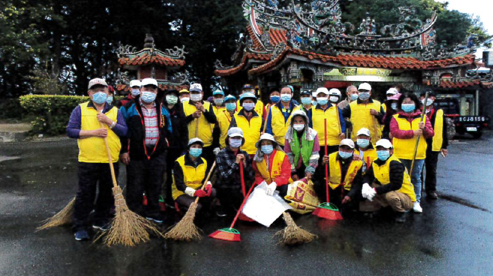 A group of people are posing for a picture in front of a building.