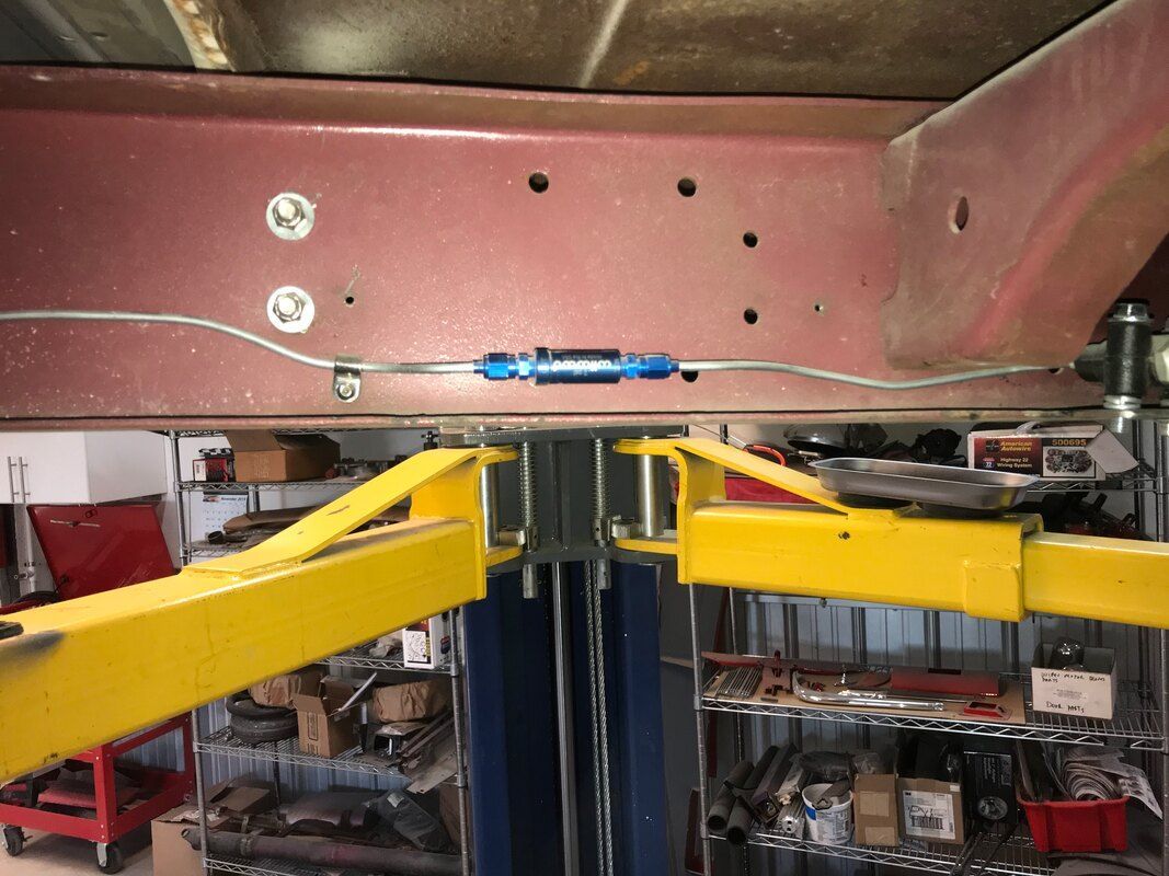 A car is sitting on a lift in a garage.