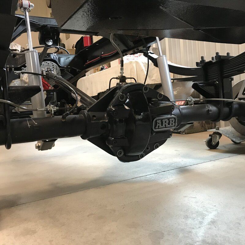 A black arb axle is sitting on a concrete floor