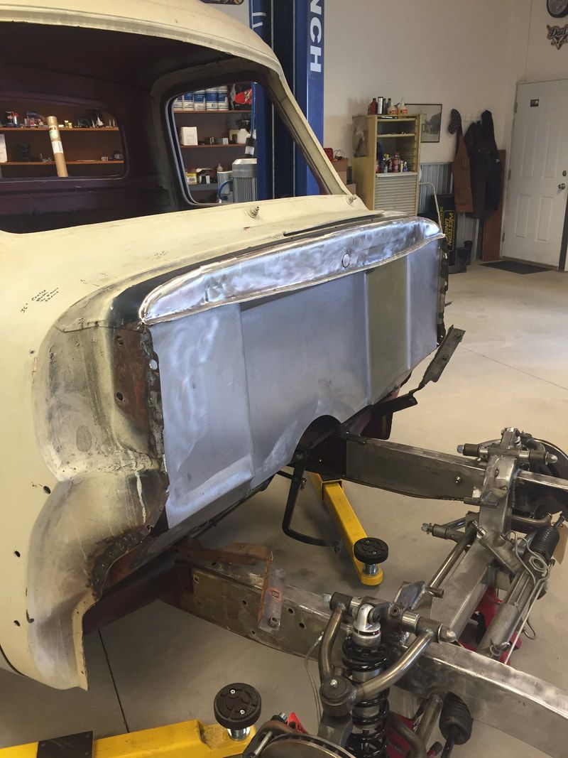 A white car is being worked on in a garage