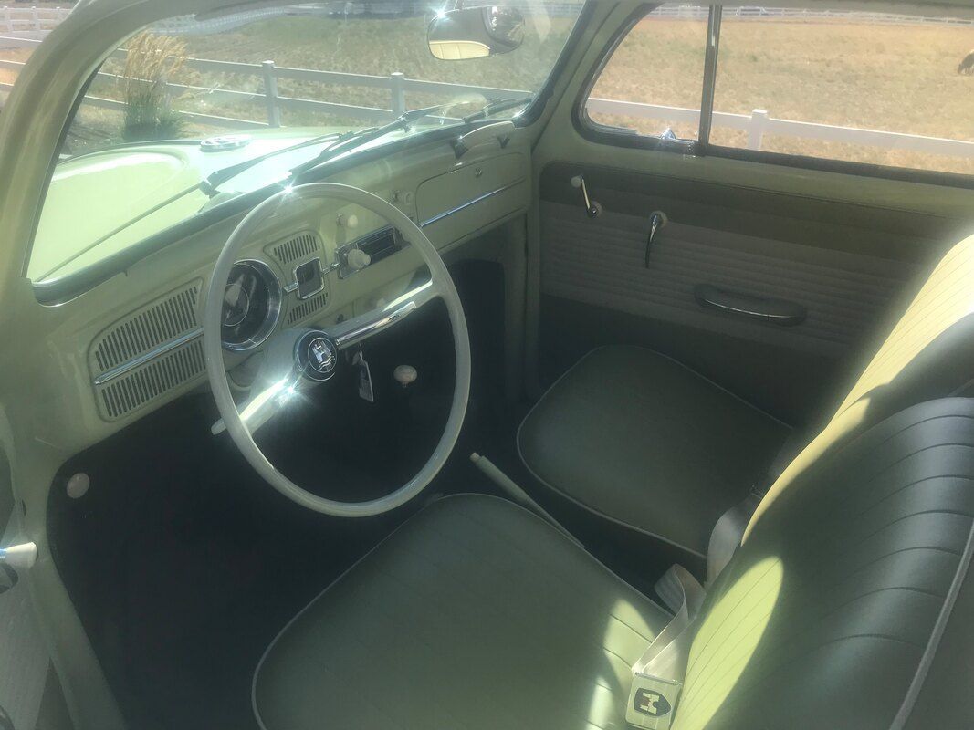 The inside of a car with a steering wheel and seats.