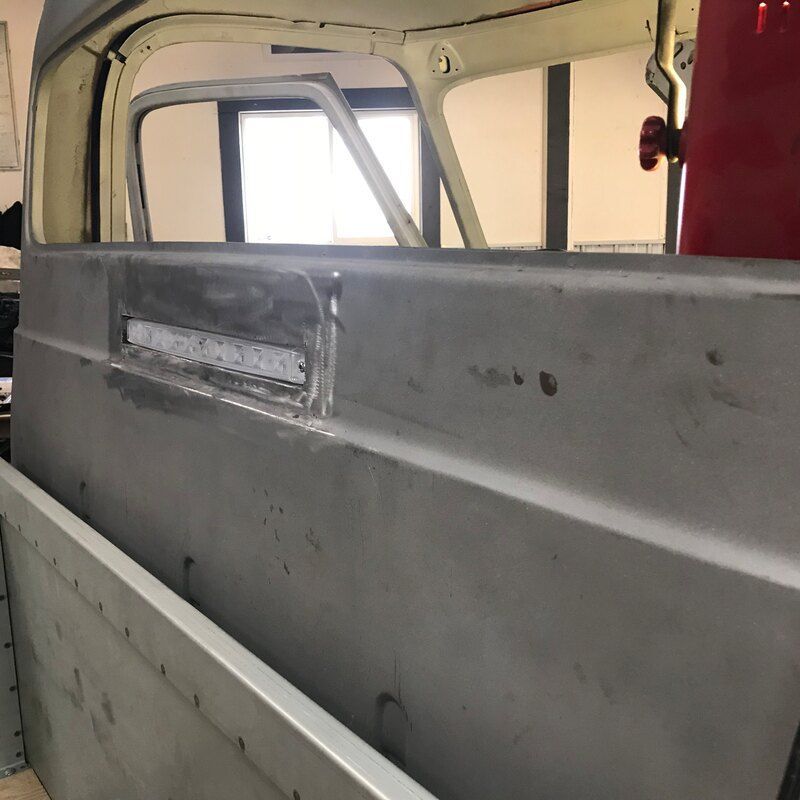 A truck is sitting in a garage with the door open