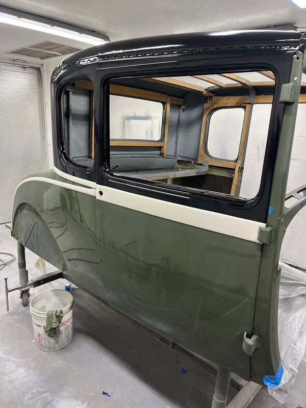 A car is being painted in a garage.