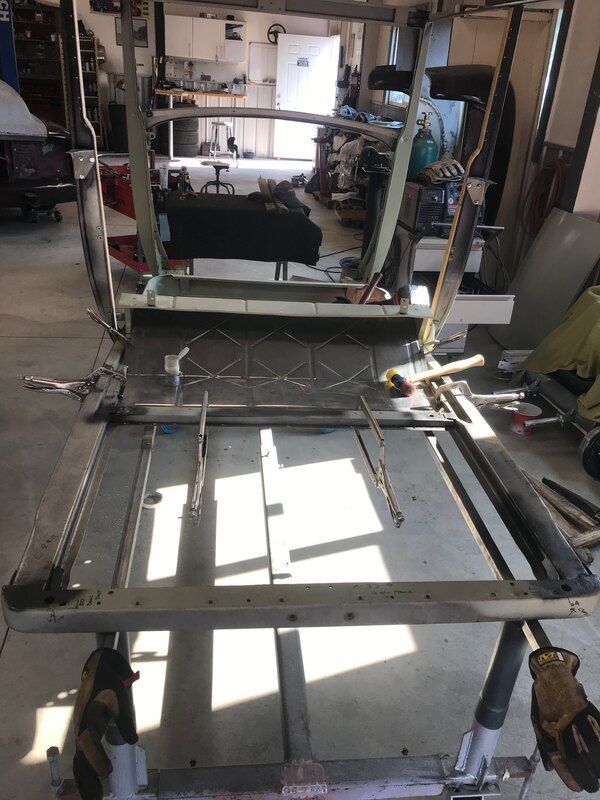 A metal frame is being worked on in a garage.