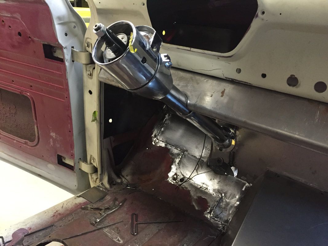 A steering wheel is being installed in a car.