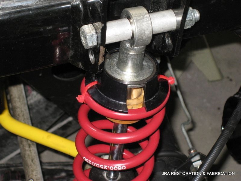 A close up of a red coil spring on a car