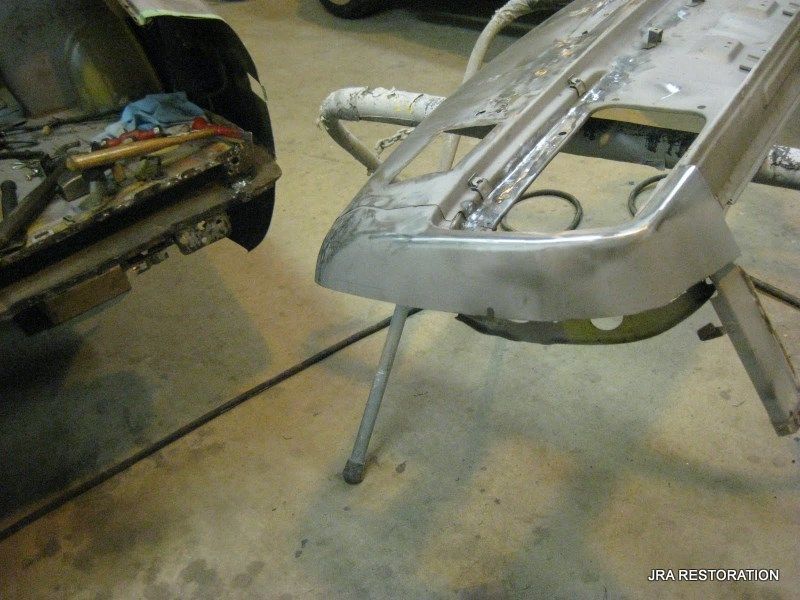A metal bumper is sitting on a metal stand in a garage.