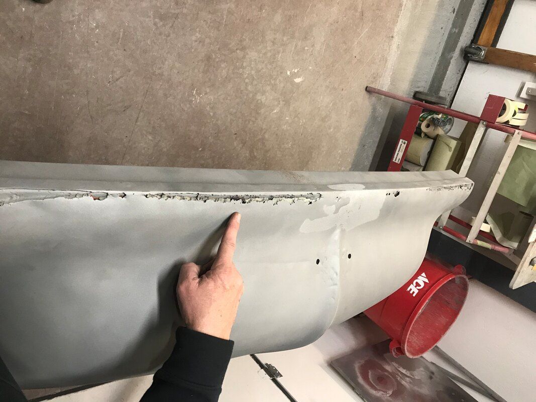 A person is pointing at a piece of metal.