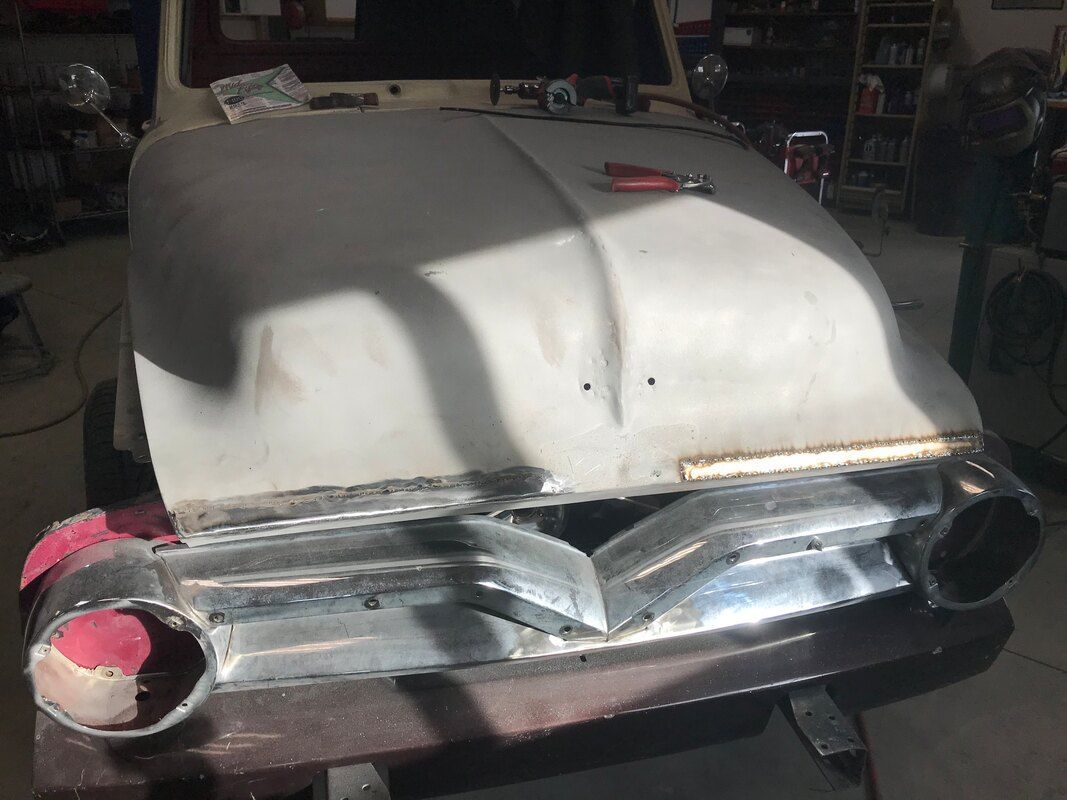 A white car is being worked on in a garage