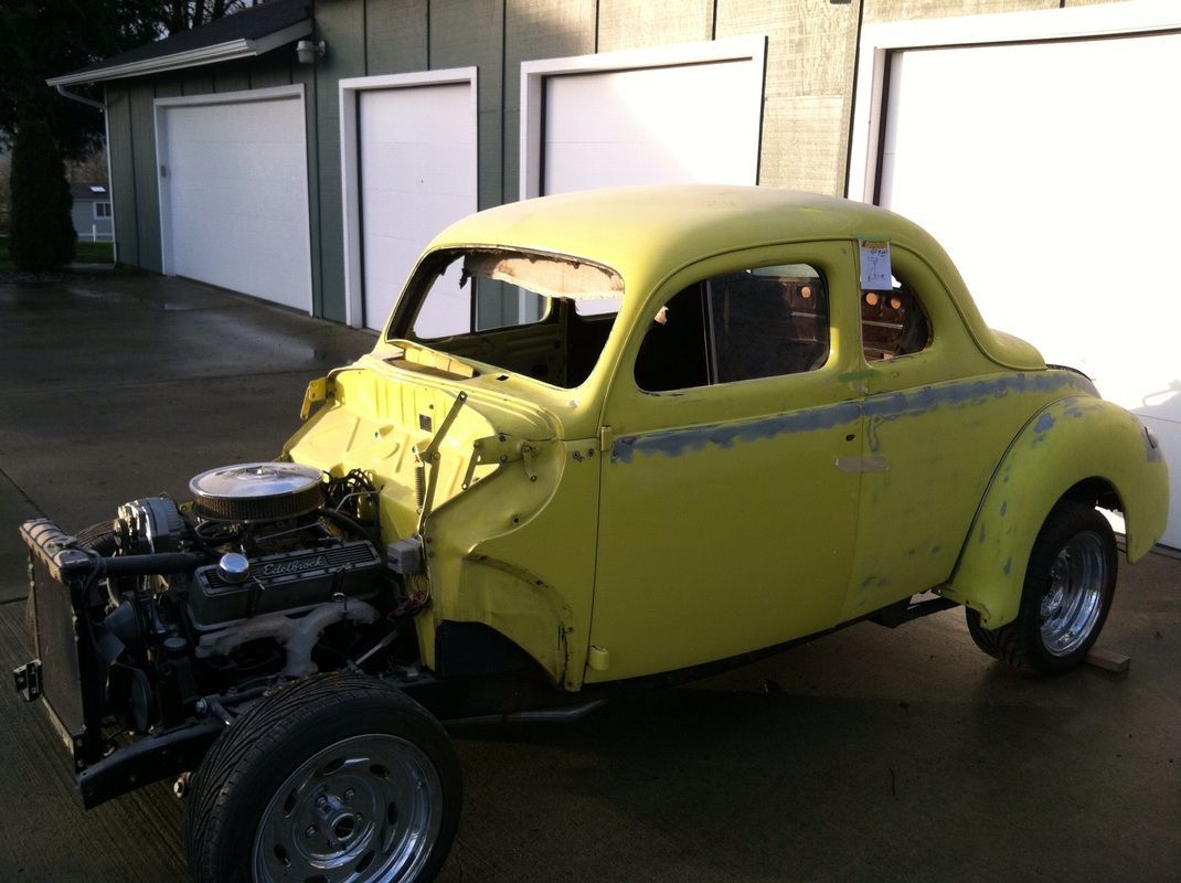 A yellow car is parked in front of a garage