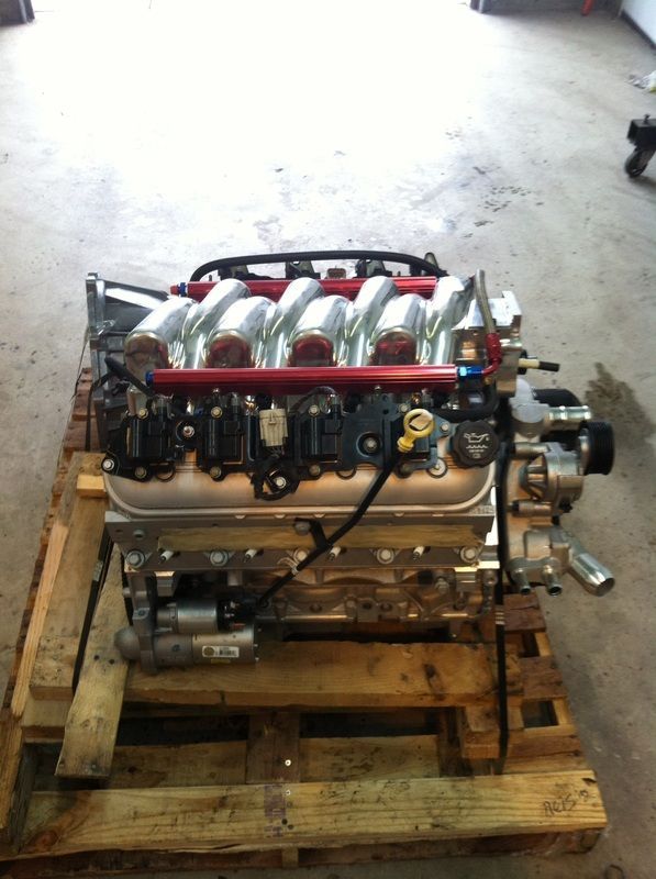 A large engine is sitting on a wooden pallet