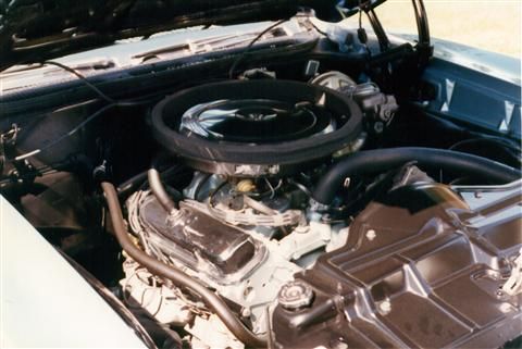 A close up of a car engine with the hood open