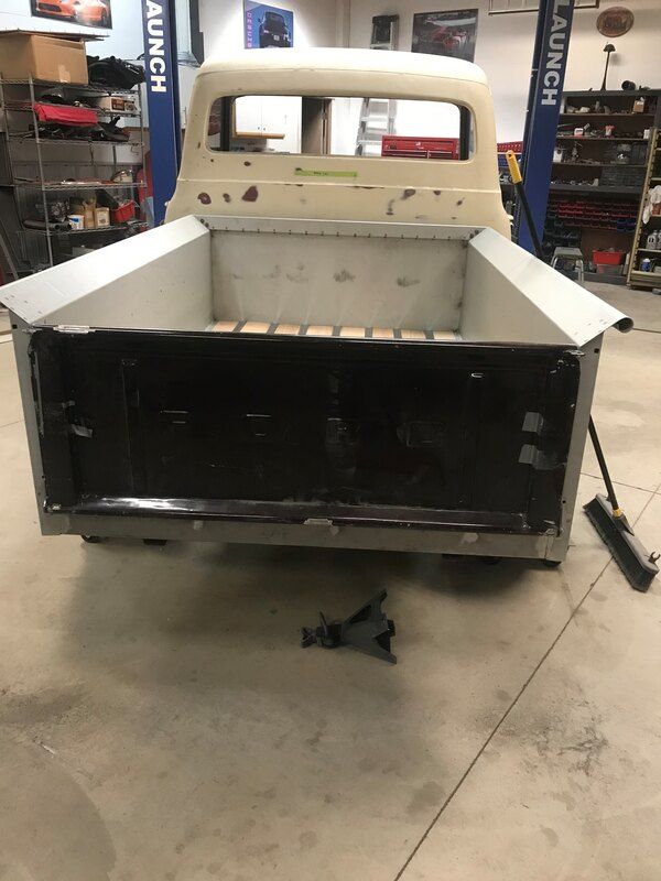 A white truck is sitting in a garage next to a launch sign