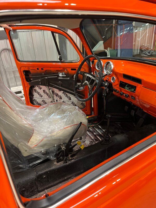 A close up of the interior of an orange car.