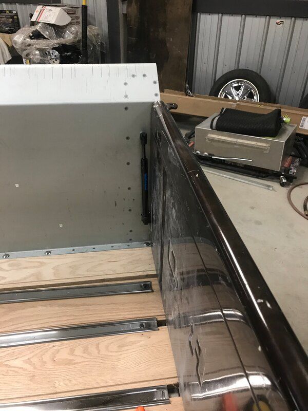 A piece of wood is sitting on a table next to a metal box.