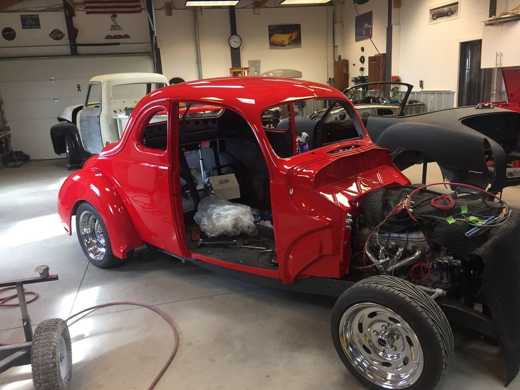 A red car is being worked on in a garage.