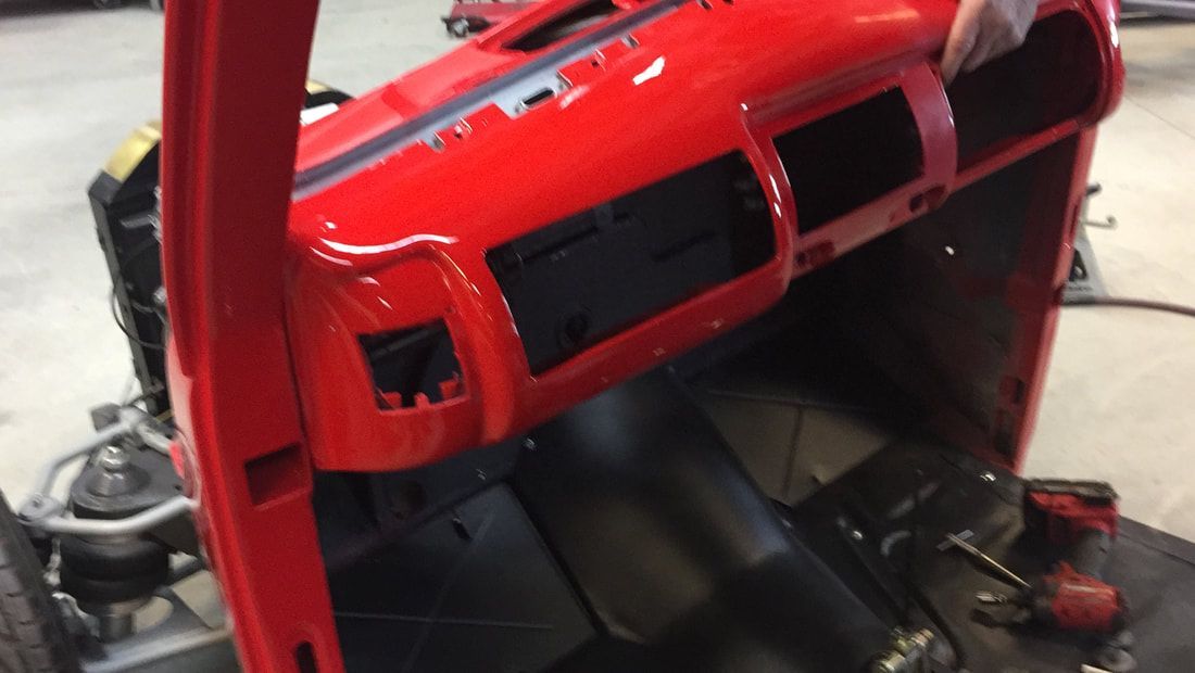 A red car is being worked on in a garage.