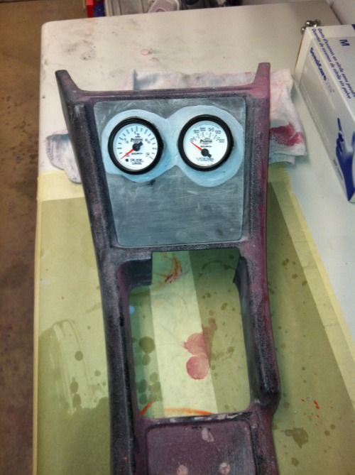 Two gauges are sitting on a table next to a box of gloves