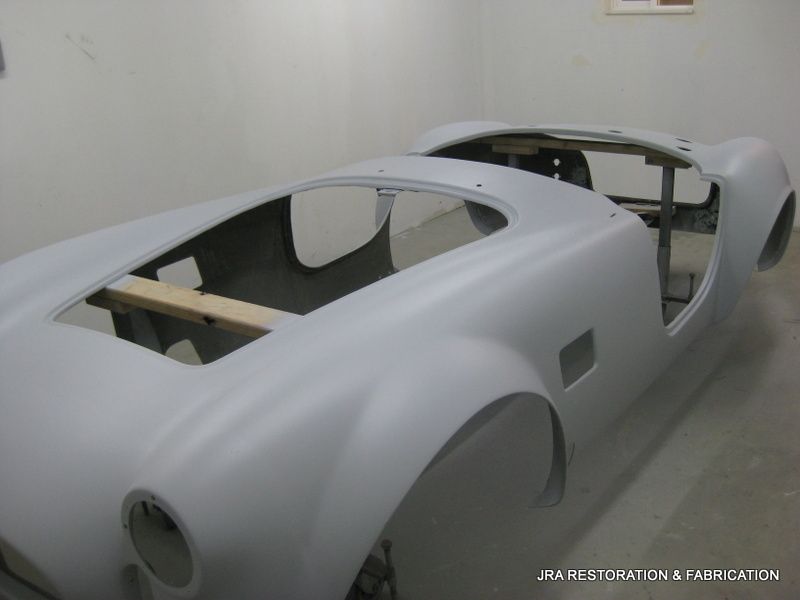A white car is being built in a garage