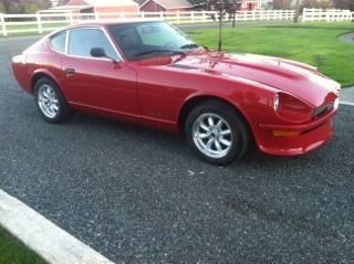 A red car is parked on the side of the road