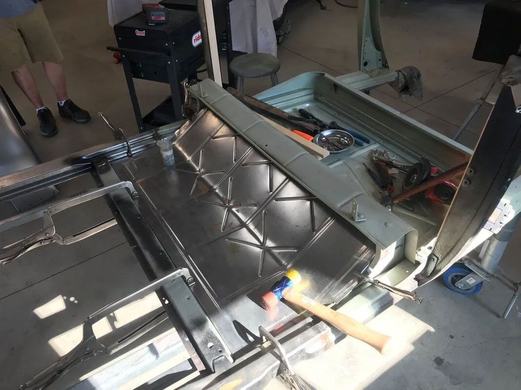 A person is working on a piece of metal in a garage.