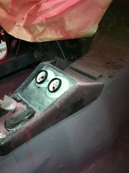 A close up of a car console with two gauges on it