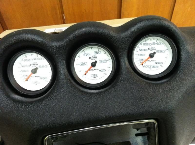 A close up of a dashboard with three gauges on it