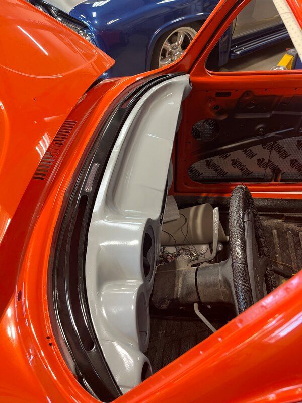 A close up of an orange car with the hood open